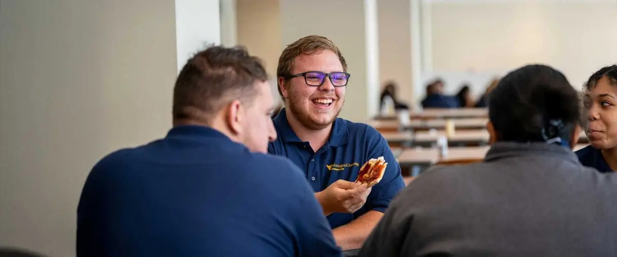 Students enjoying pizza at table