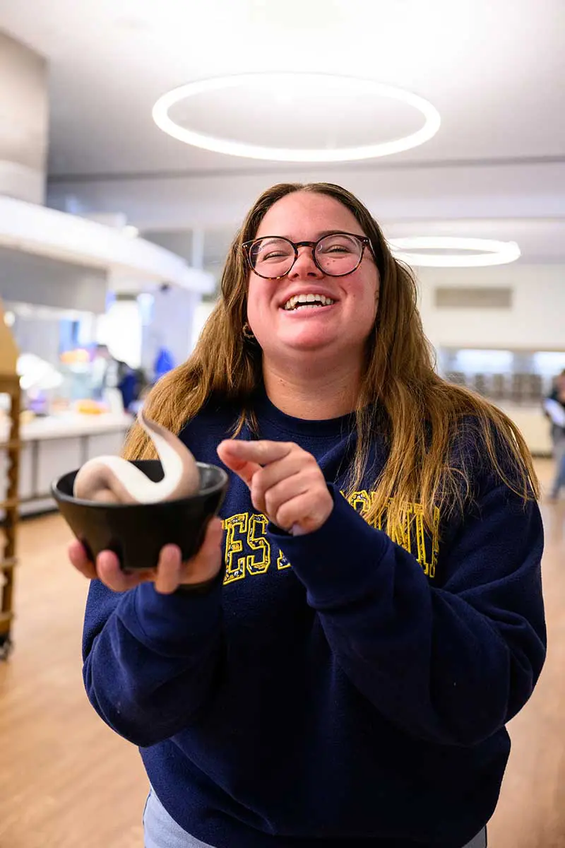 Student happily holding a bowl of ice cream