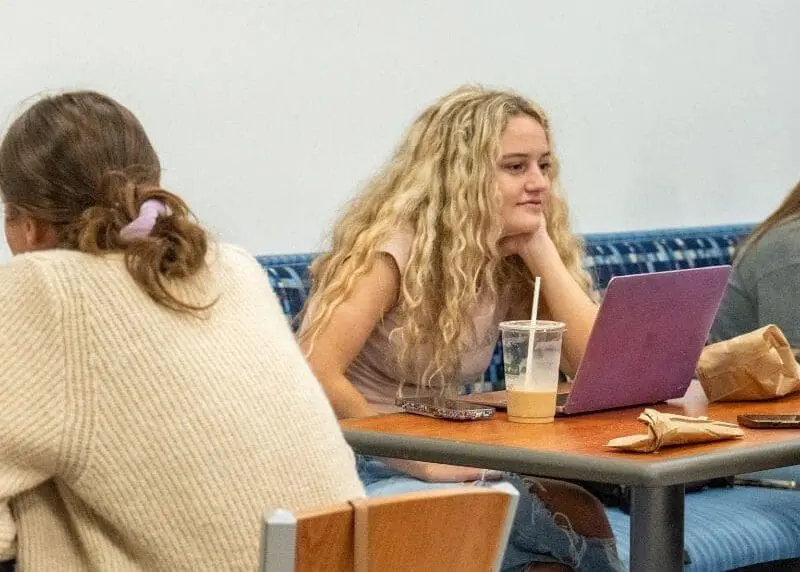 Students sitting with laptops and enjoying iced coffee