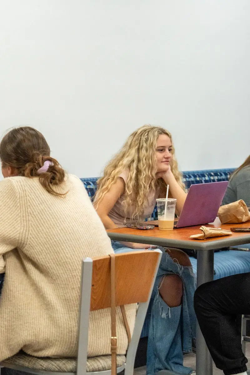 Students sitting with laptops and enjoying iced coffee