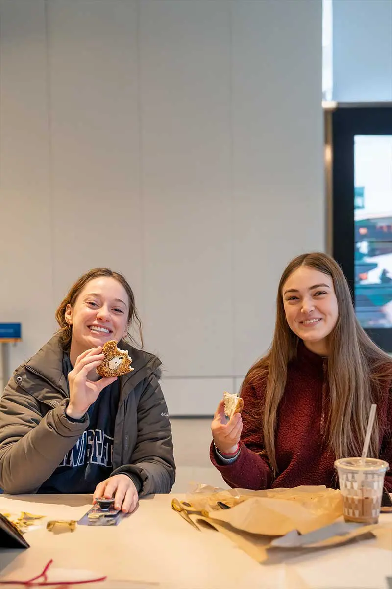 Two students happily enjoying bagel