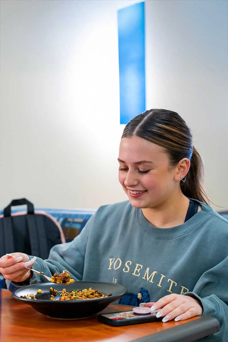 Student happily eating a bowl of food