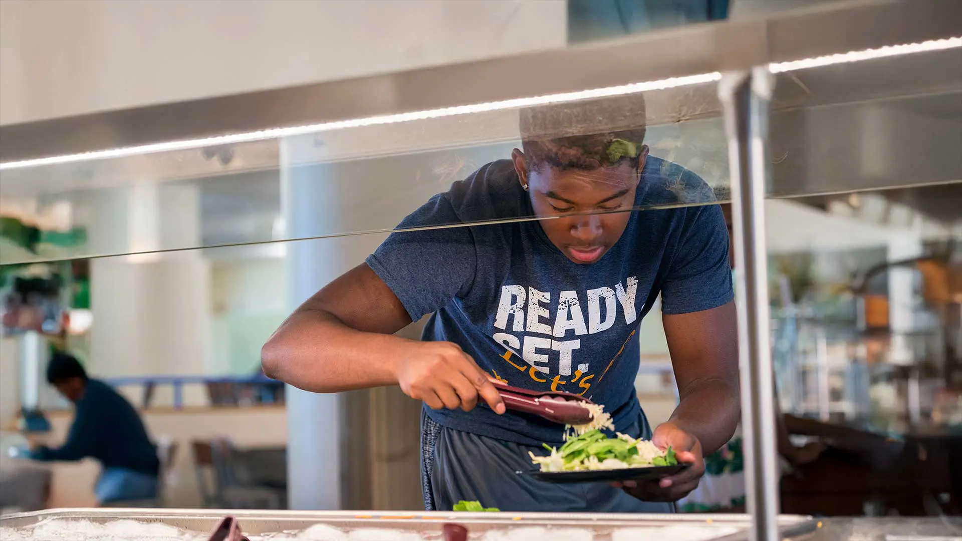 Student making salad at salad bar