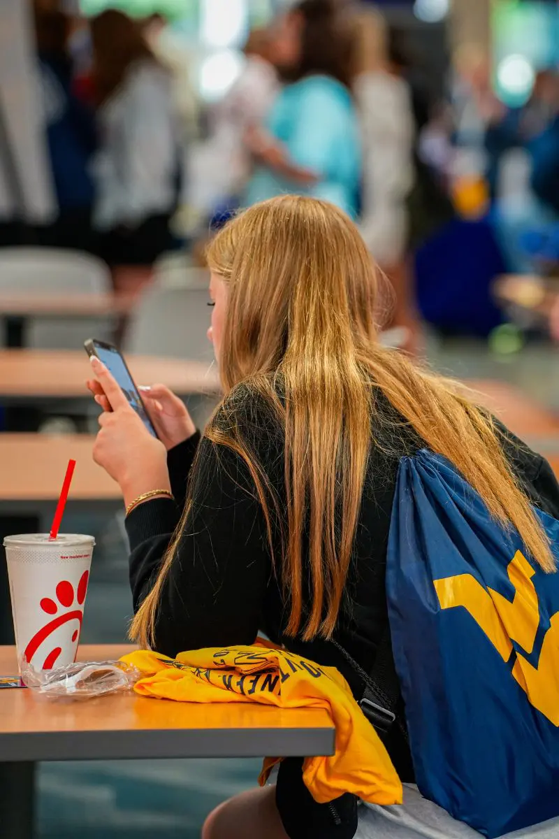 student on their cell phone in the dining hall
